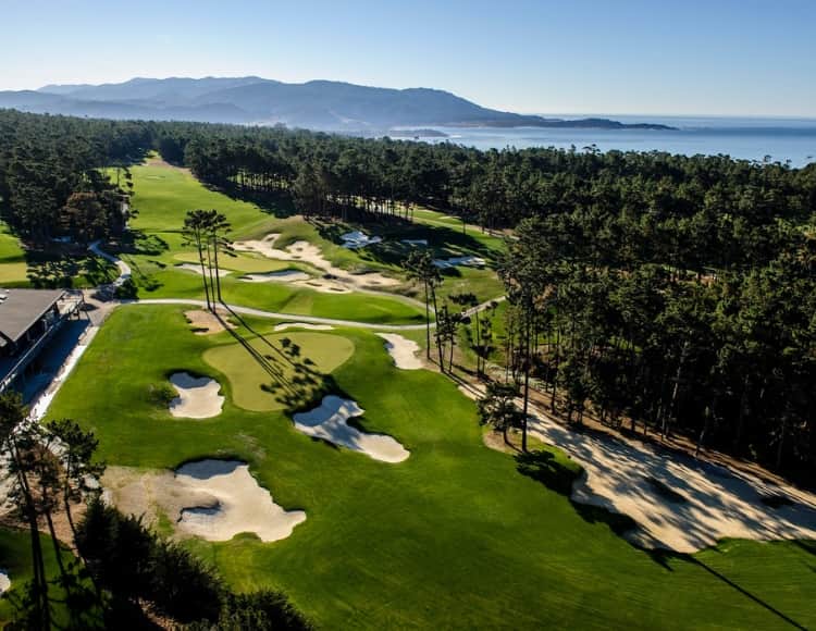 The 9th and 18th holes at Poppy Hills Golf Course with the Pacific Ocean in the distance, framed by Del Monte Forest pines. Photo courtesy of Poppy Hills Golf Course / Northern California Golf Association (poppyhillsgolf.ncga.org).