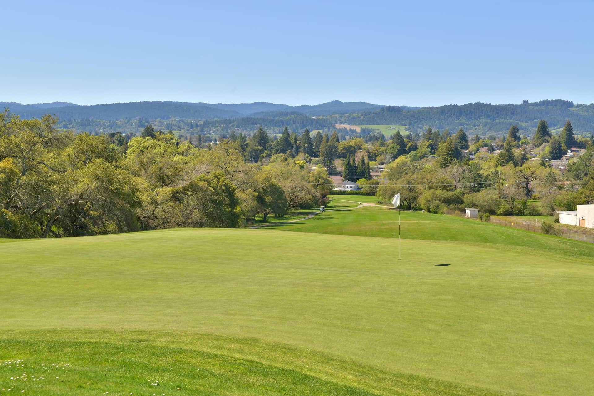 Putting green and flagstick at Healdsburg Golf Club at Tayman Park, Healdsburg, CA, with sweeping views of Dry Creek Valley and Fitch Mountain beyond. Photo credit: Healdsburg Golf Club at Tayman Park (healdsburggolfclub.com).