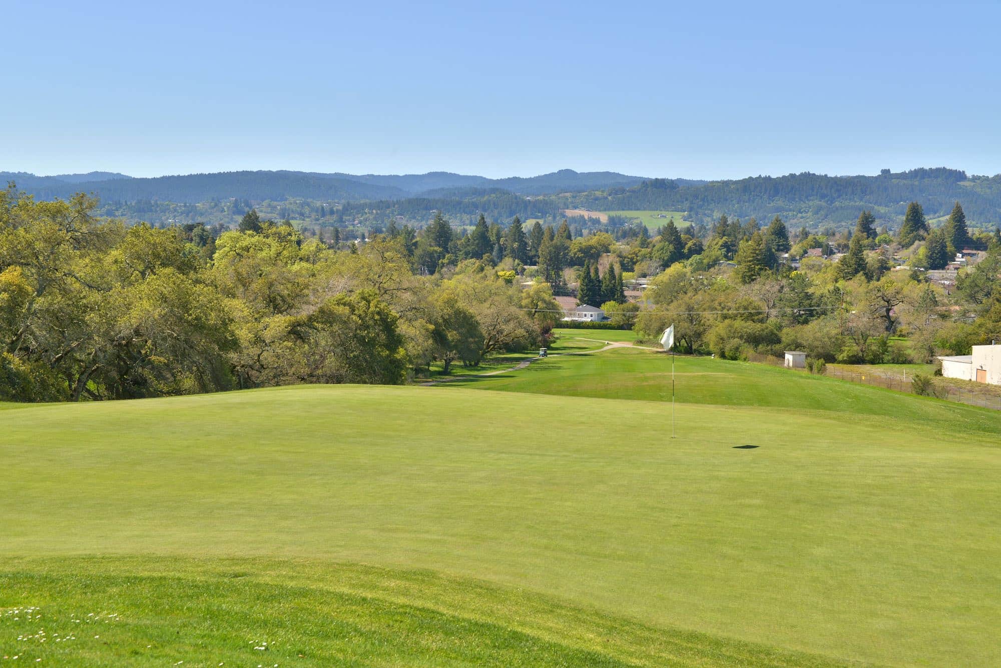 Putting green and flagstick at Healdsburg Golf Club at Tayman Park, Healdsburg, CA, with sweeping views of Dry Creek Valley and Fitch Mountain beyond. Photo credit: Healdsburg Golf Club at Tayman Park (healdsburggolfclub.com).