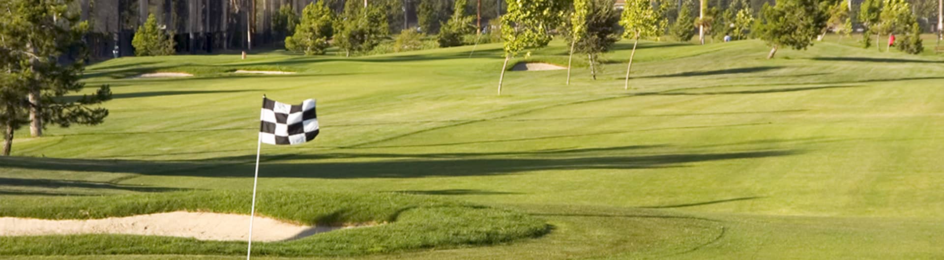 A rolling green guarded by sand bunkers with the course's signature black-and-white checkered flag at Rancho del Pueblo Golf Course, San Jose, California. Photo courtesy of Rancho del Pueblo Golf Course (City of San Jose / CourseCo Golf Management), ranchodelpueblo.com.
